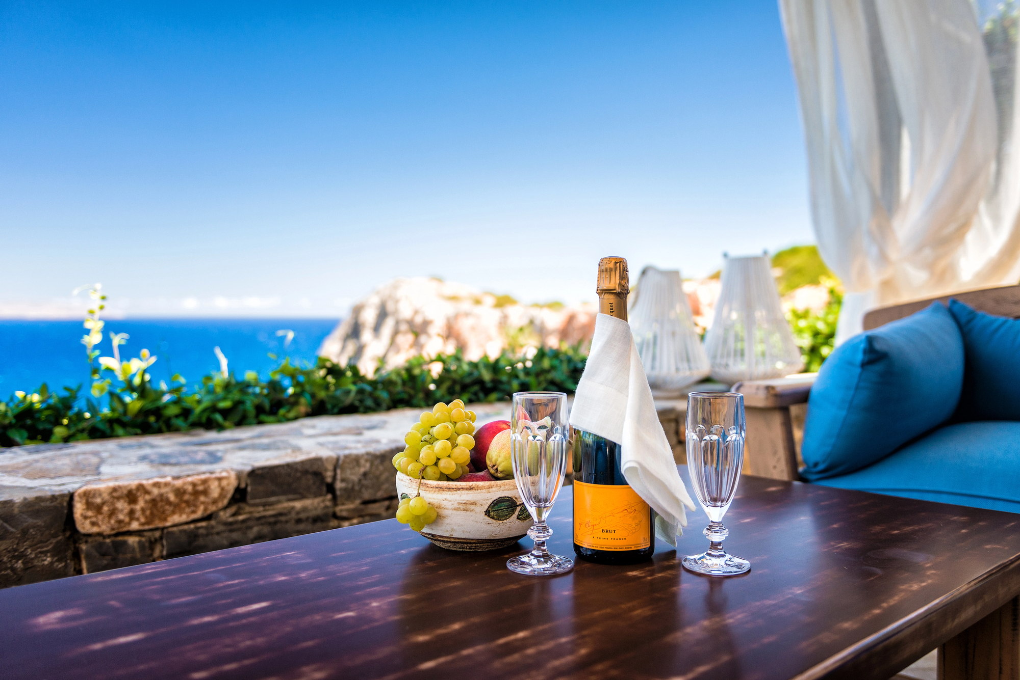 paisaje de mar mediterraneo con una mesa de vino con uvas